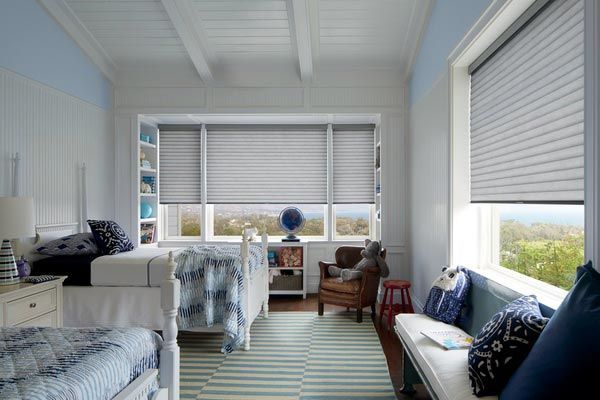 A bedroom with two beds , a couch , and a window with blinds.