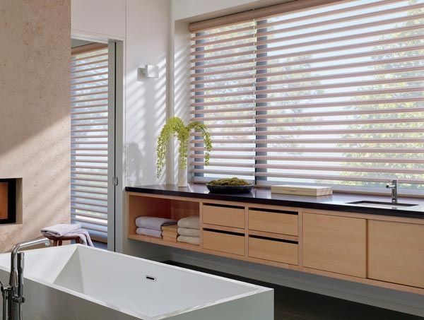 A bathroom with a bathtub and a window with blinds