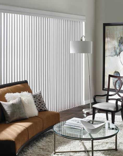 A living room with a couch , chair , coffee table and blinds.