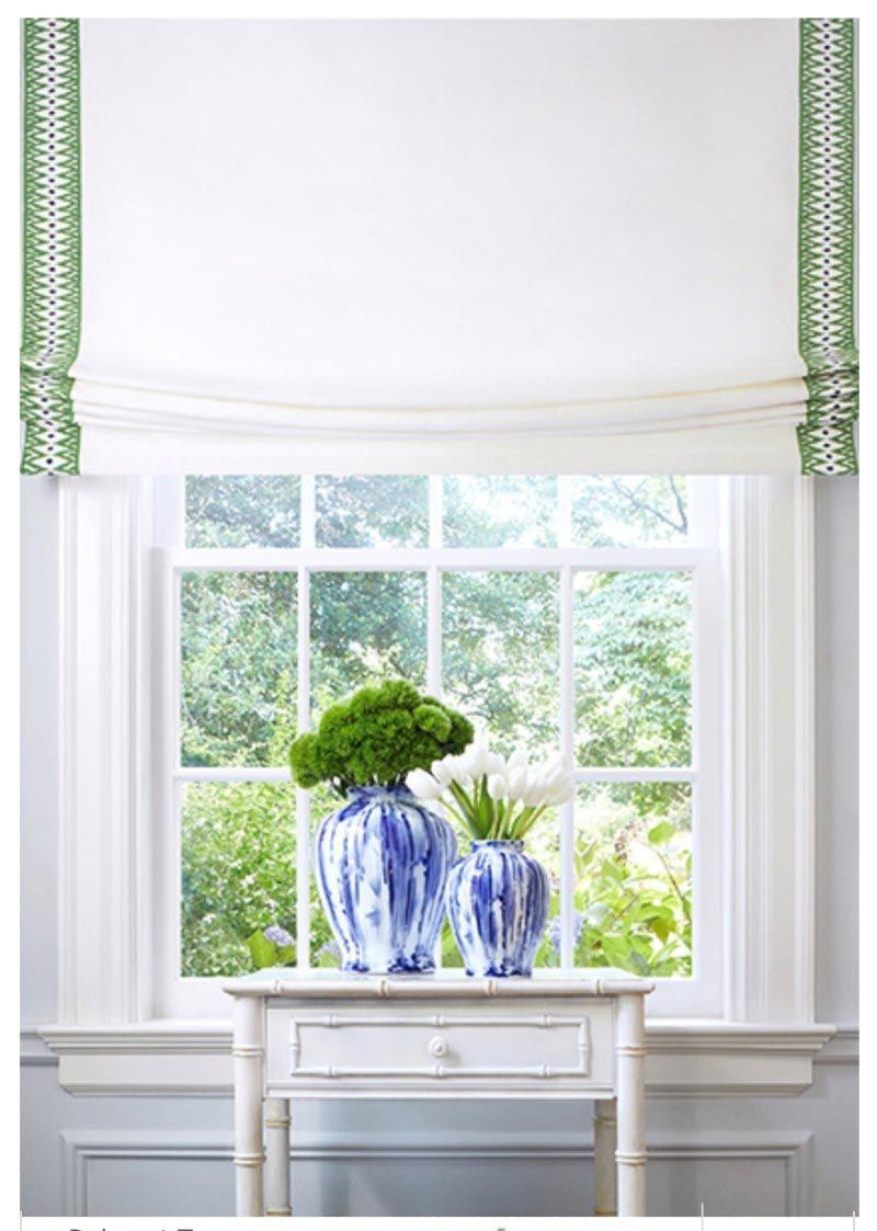 Two blue and white vases are sitting on a table in front of a window.