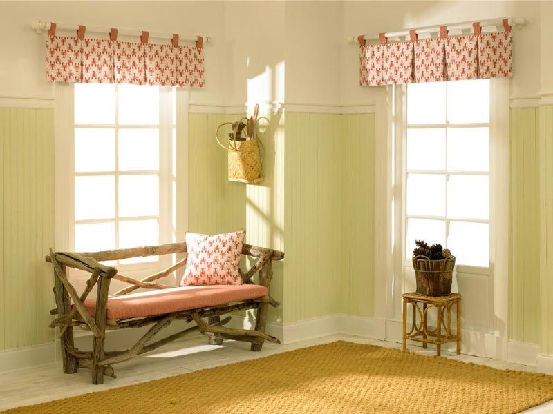 A living room with a wooden bench and two windows