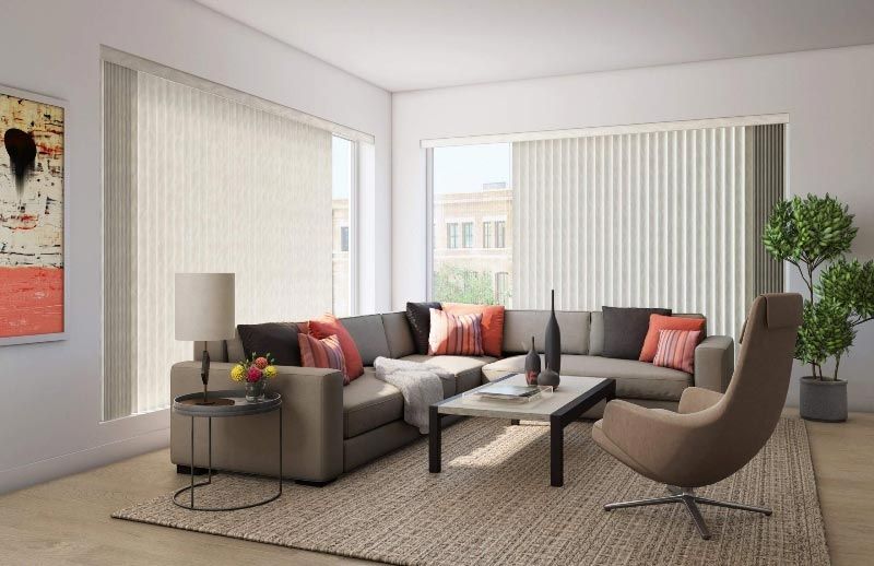 A living room with a couch , chair , coffee table and blinds.