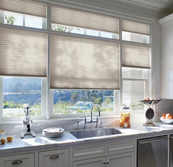 A kitchen with a sink , cabinets , and a window with blinds.