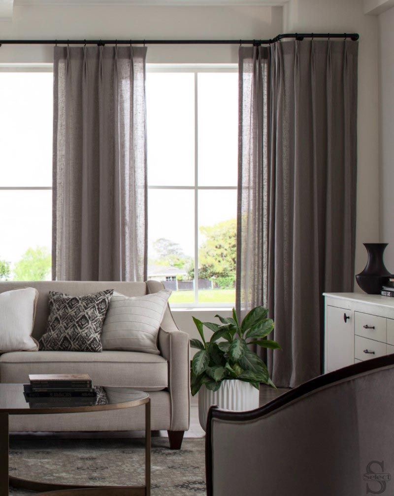 A living room with a couch , chair , coffee table and window.