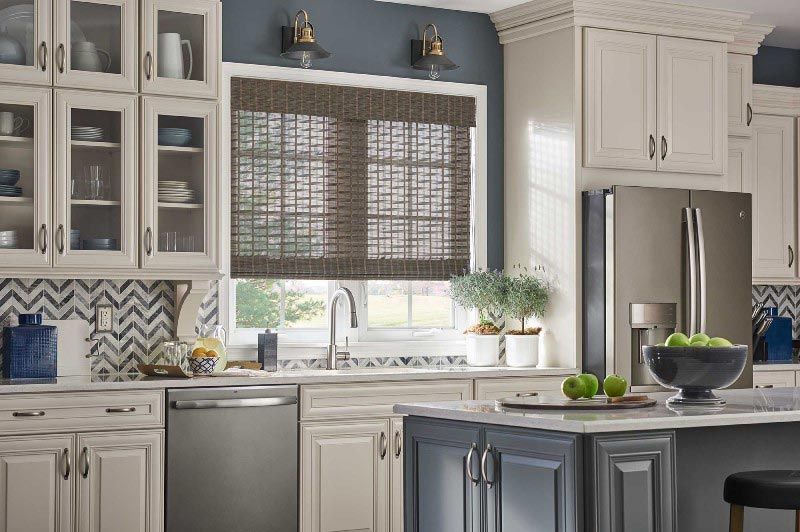 A kitchen with white cabinets and a stainless steel refrigerator.