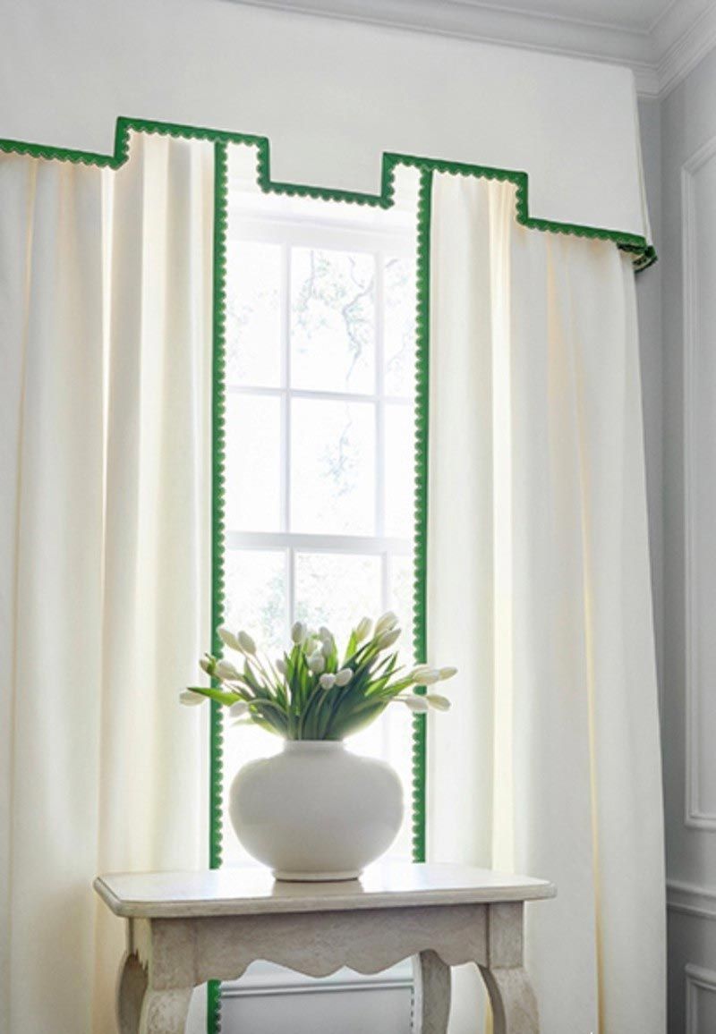 A vase of flowers is sitting on a table in front of a window.