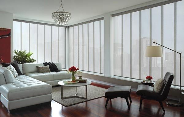 A living room with a white sectional couch , chairs , and a coffee table.
