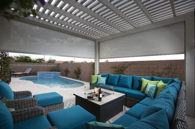 A patio with blue furniture and a swimming pool.