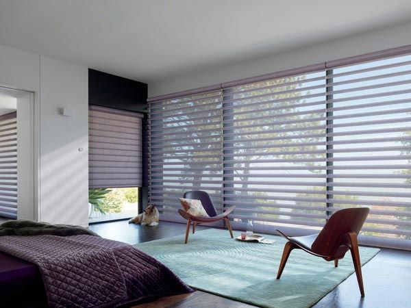 A bedroom with a bed , chairs and a rug.
