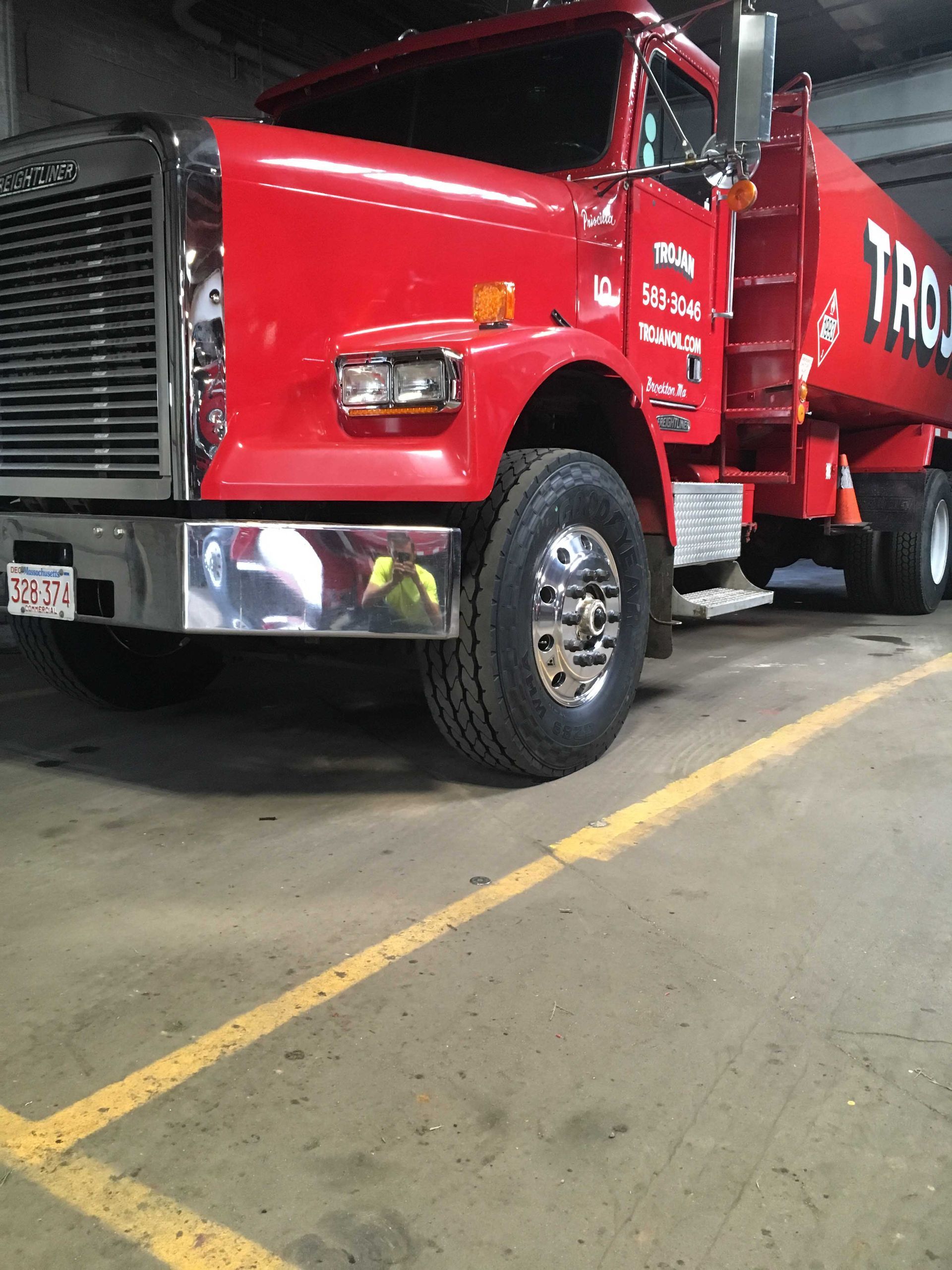 Red dump truck parked indoors in a garage or warehouse.