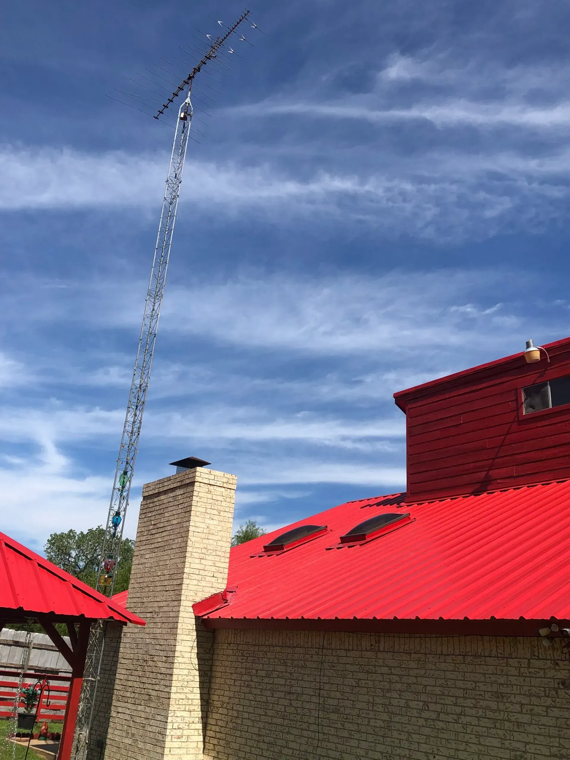 A brick building with a red roof and a chimney