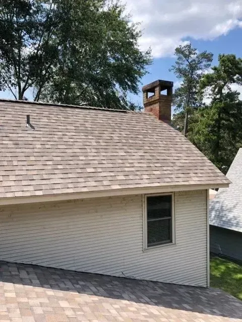 A white house with a chimney on the roof