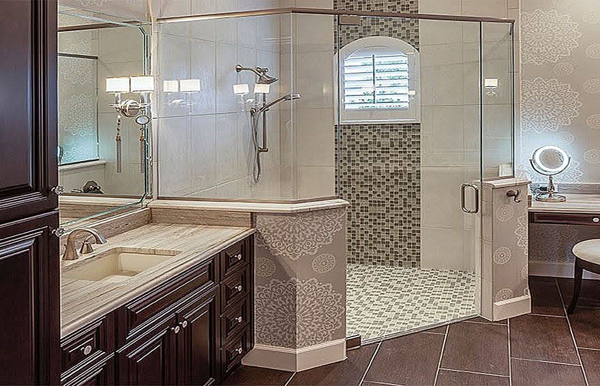 Luxurious bathroom with dark wood cabinets, double sinks, glass shower, and mosaic-tiled shower area.