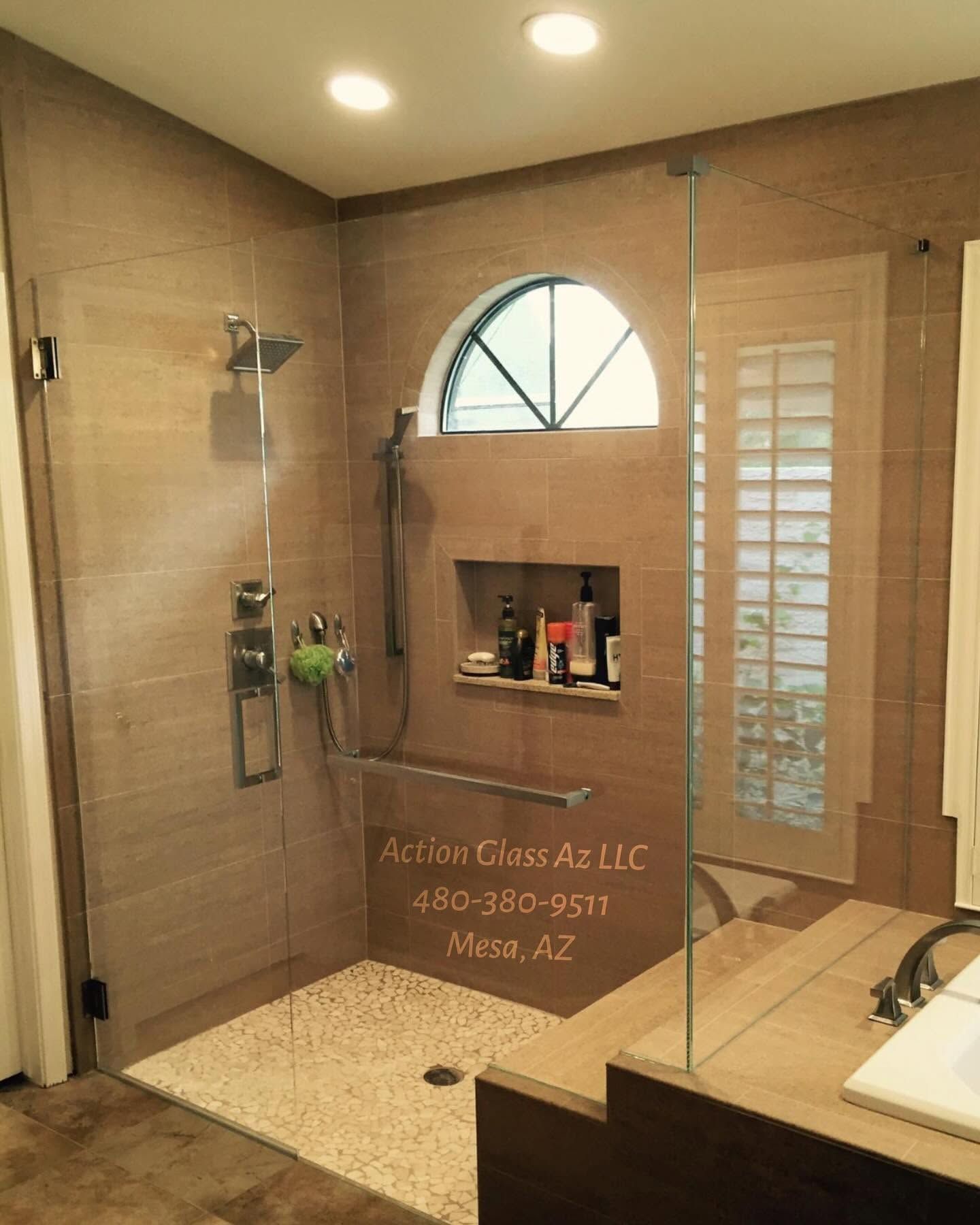 Glass walk-in shower with beige tile, built-in shelf, and frosted window in a bathroom.