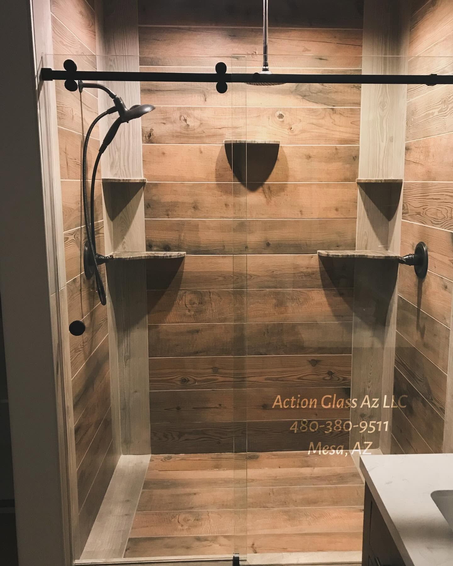 Wood-paneled shower stall with glass door hardware and corner shelves.