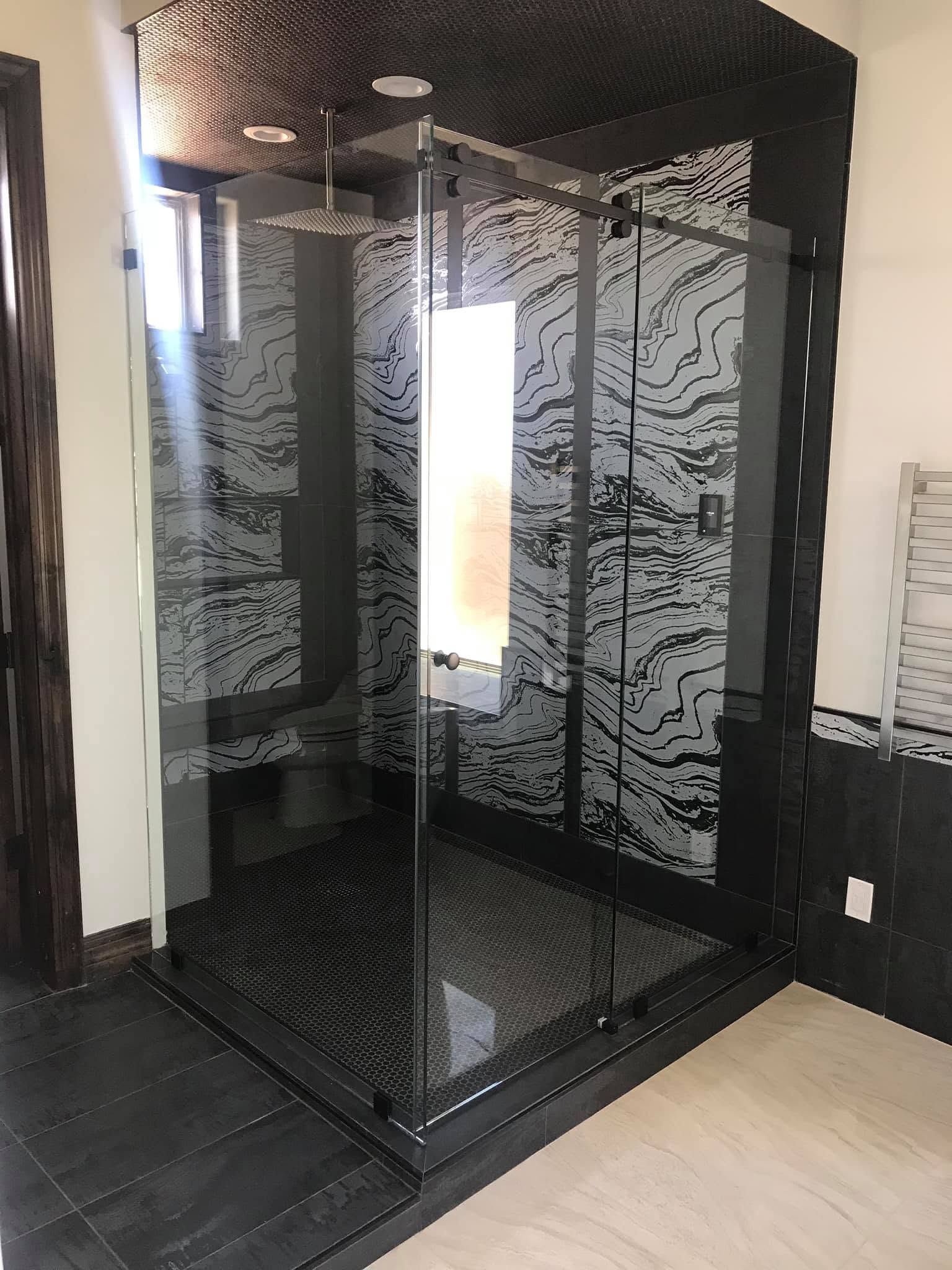 Modern glass-front elevator in a sleek black frame with reflective walls and light wood flooring.