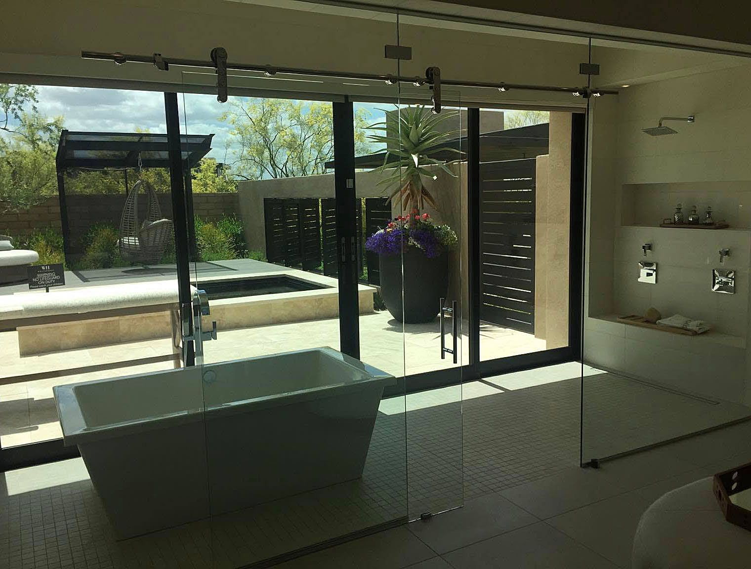 Modern living room with floor-to-ceiling glass doors opening to a patio and pool.