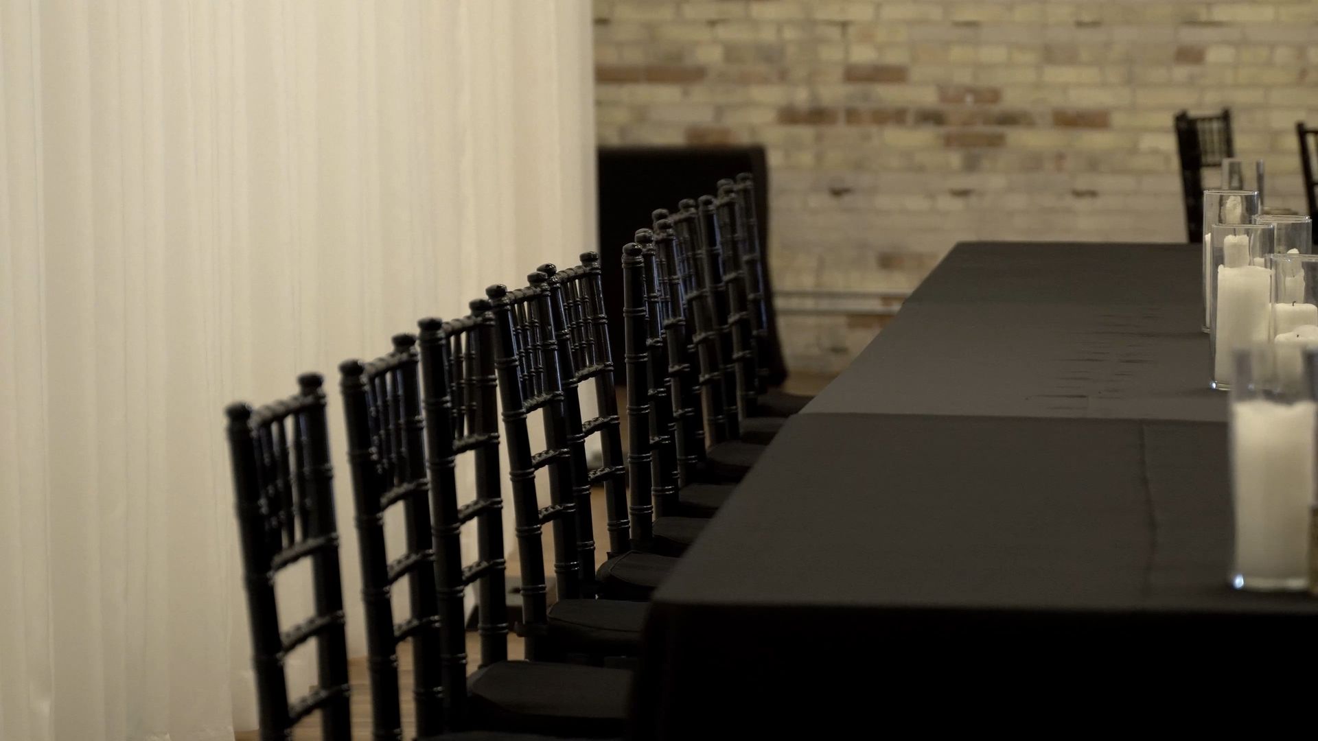 Long banquet table with black chairs set in a formal dining room.