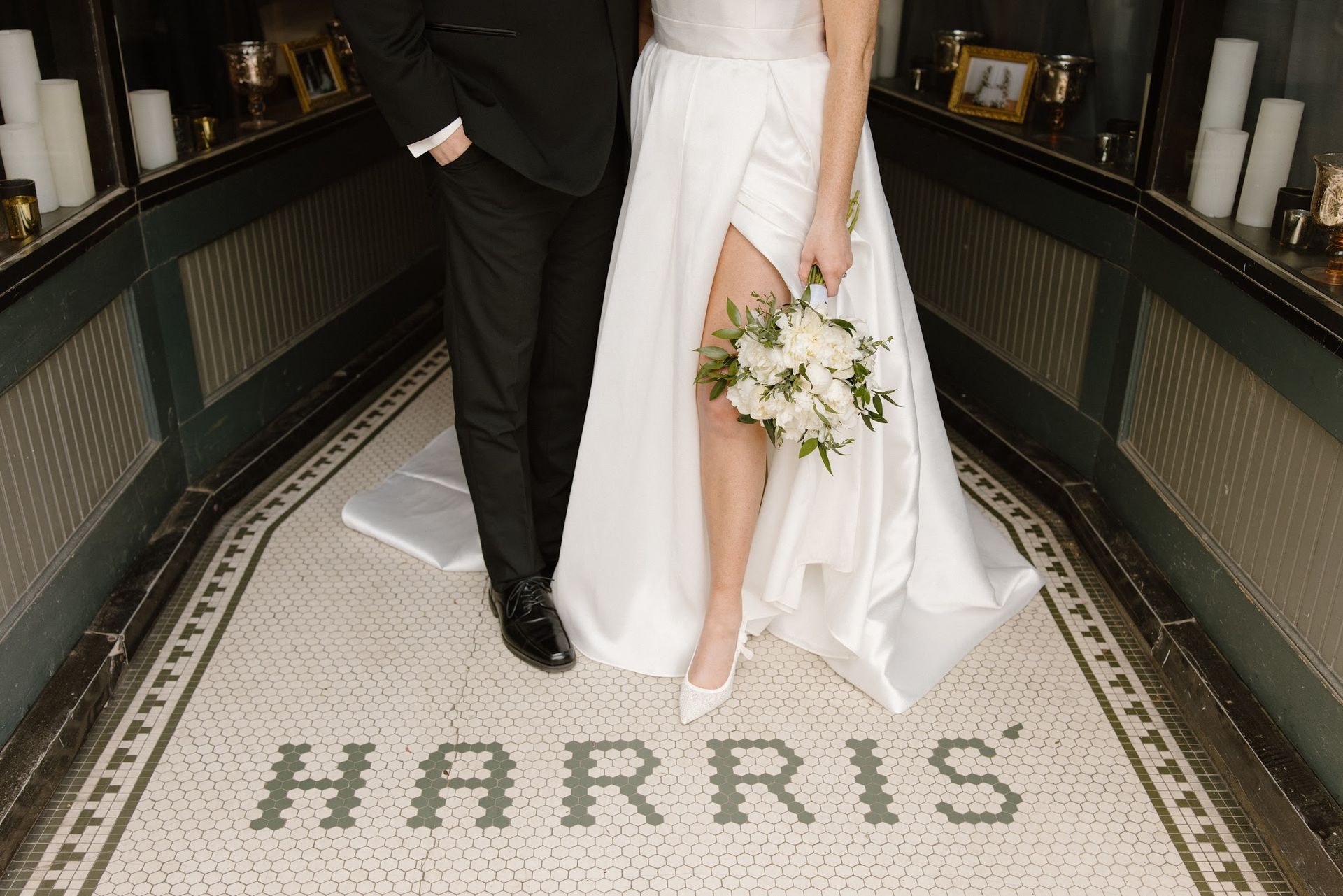 Bride and groom standing on Harris mosaic floor, bride holding white bouquet
