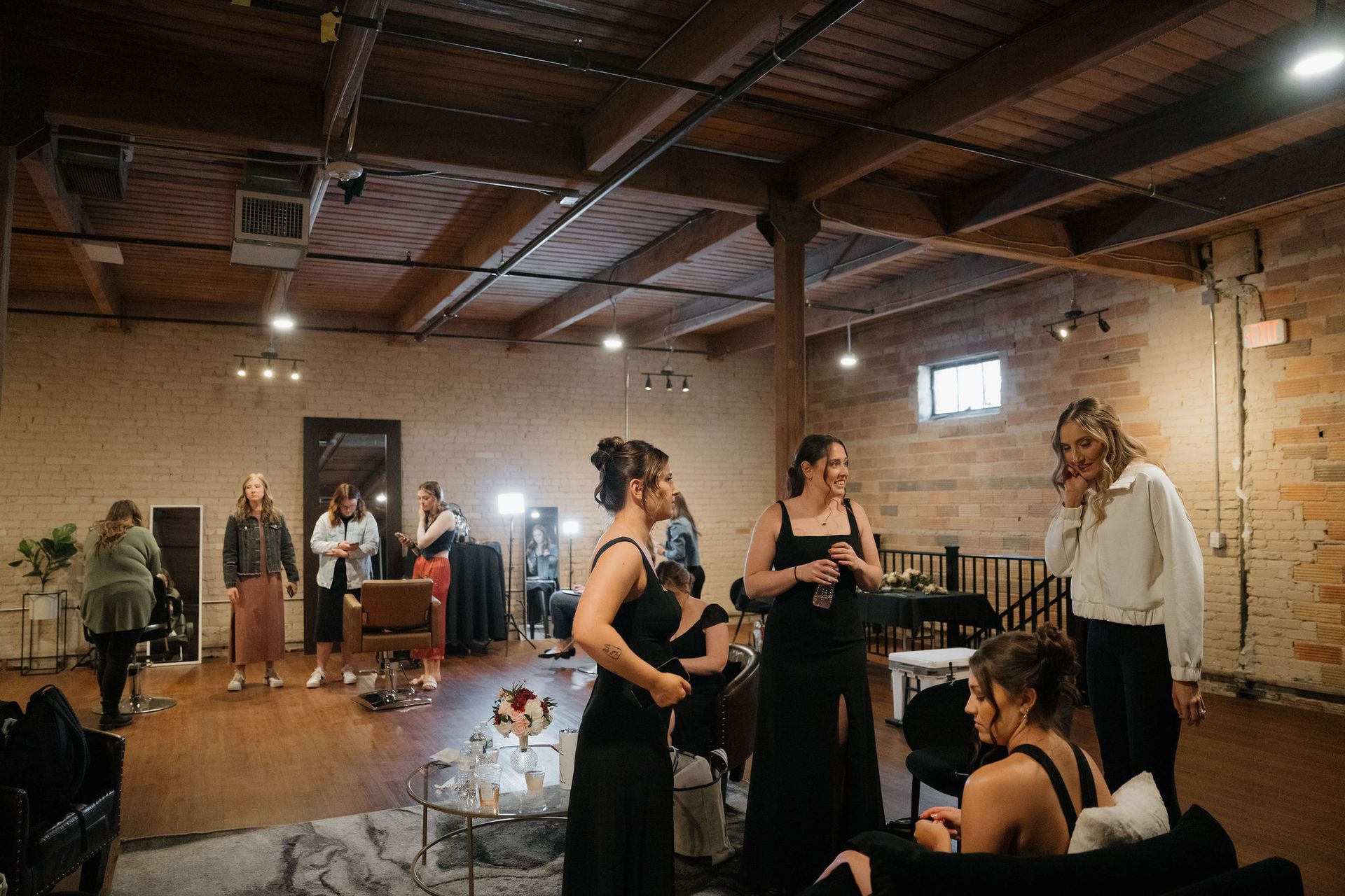 Guests mingling in a rustic indoor event hall with warm lighting and wood beams