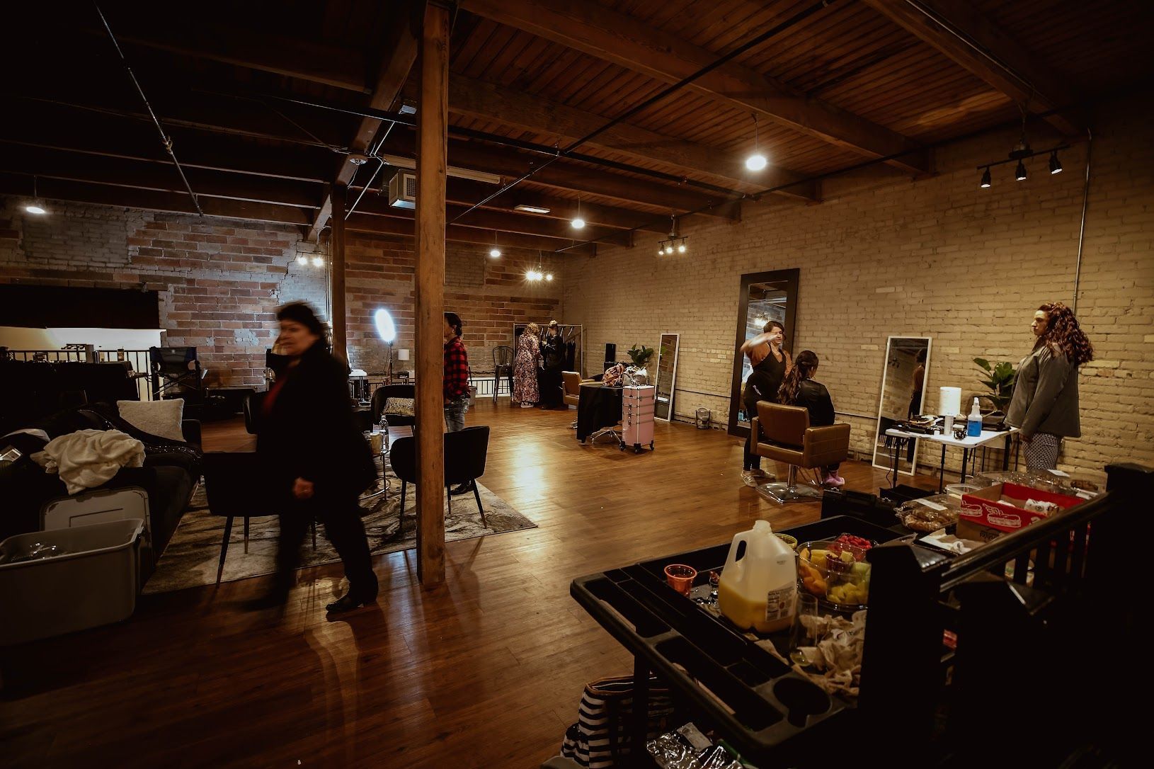 Indoor market hall with people browsing stalls and displays under warm wooden beams and lights