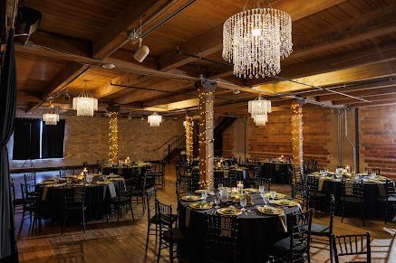 Elegant wood-paneled banquet hall with chandeliers and set tables for an event