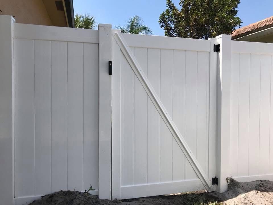 A white fence with a gate attached to it.