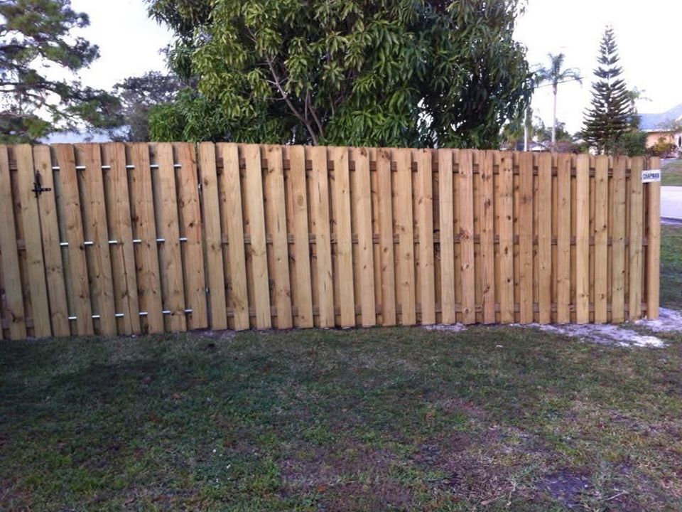 A wooden fence is sitting in the middle of a grassy field.