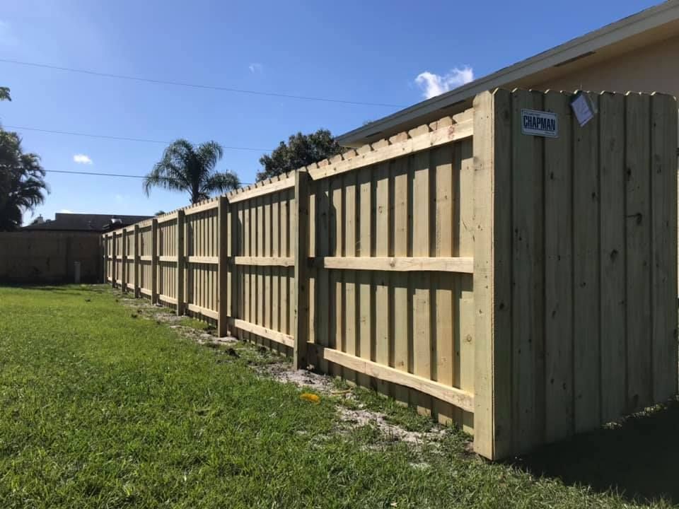 A wooden fence is sitting in the middle of a lush green field.