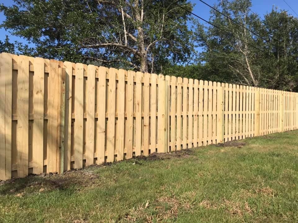 A wooden fence is sitting in the middle of a grassy field.