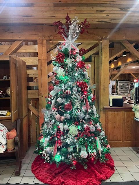 Decorated Christmas tree with red and silver ornaments in a rustic wooden room