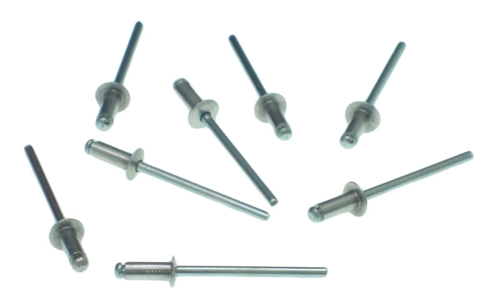 Assorted metal rivets and fasteners scattered on a white background