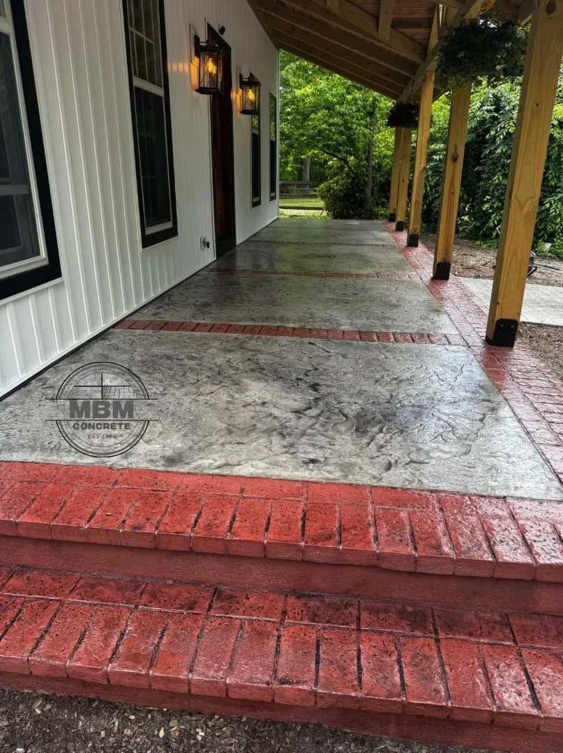 Porch with red brick steps and border, gray concrete, white siding, and wooden columns.