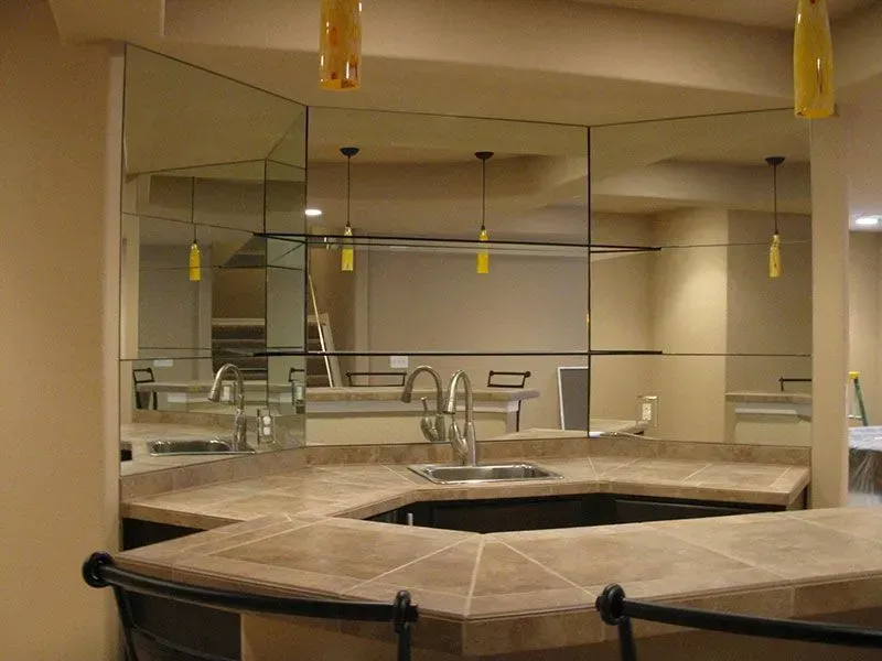 Empty indoor spa with a tiled hot tub, mirrors, and hanging pendant lights