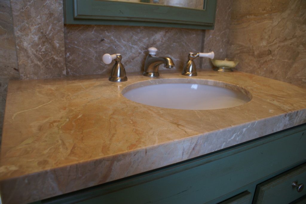 A clean bathroom featuring a modern sink and a large mirror reflecting the bright, well-lit space.