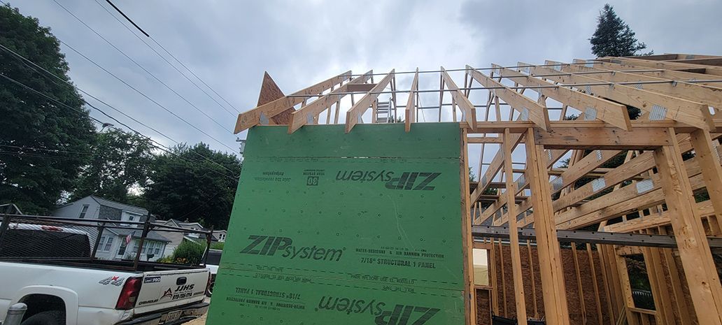 A green sheet of plywood is sitting on top of a wooden structure.