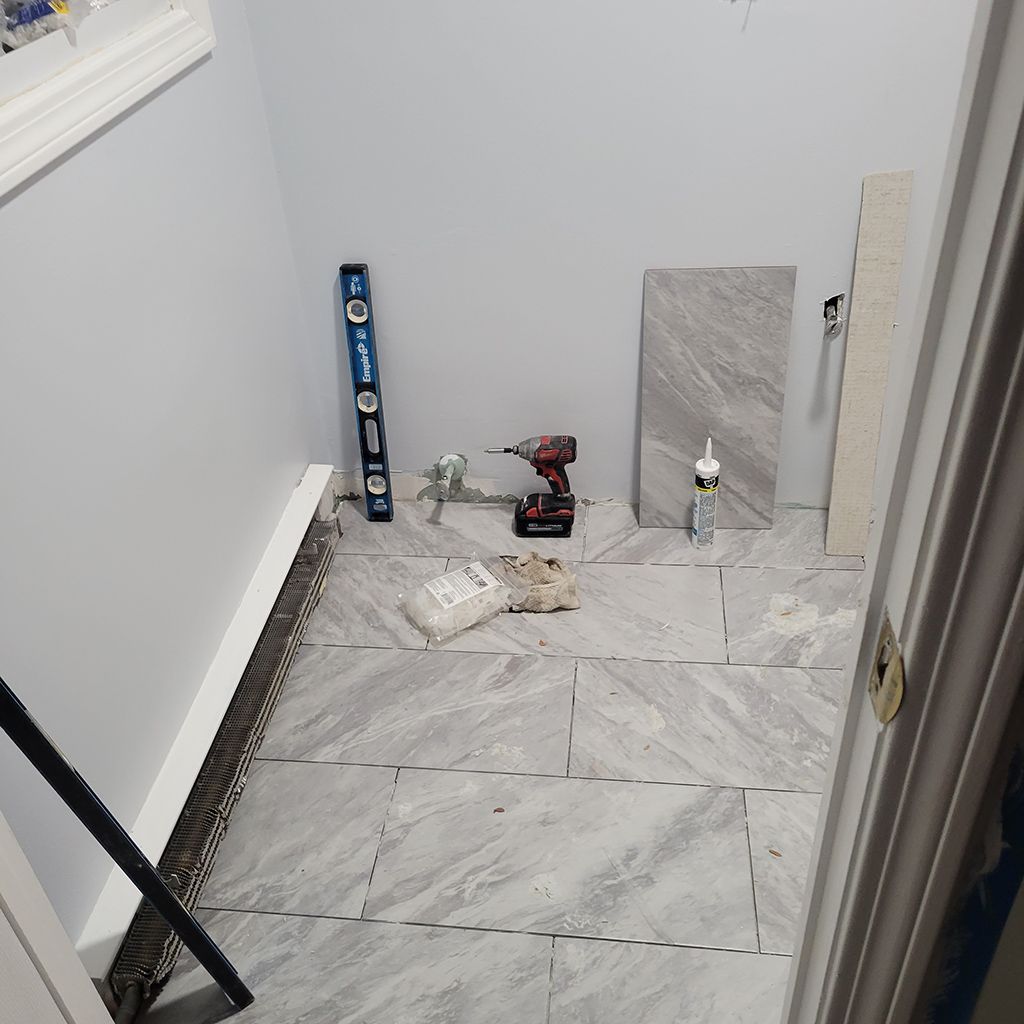A room with a drill and a level on the floor