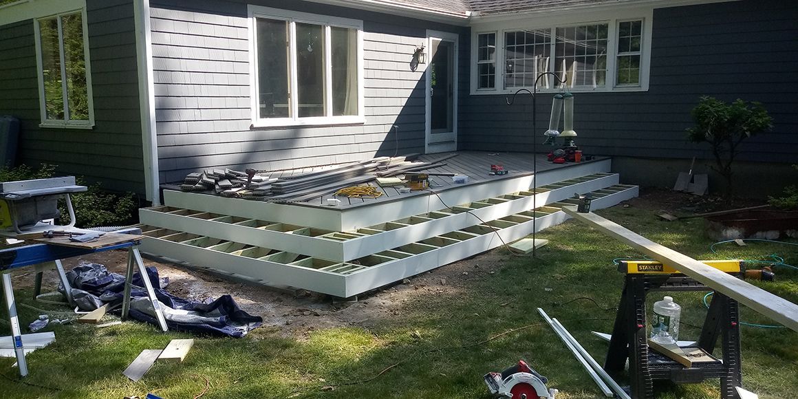 A deck is being built in the backyard of a house.