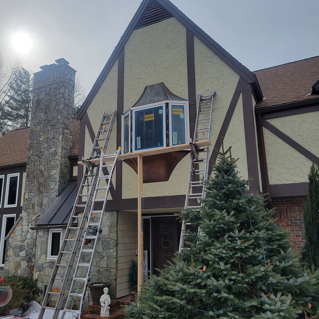 A house with a window being installed on the side of it