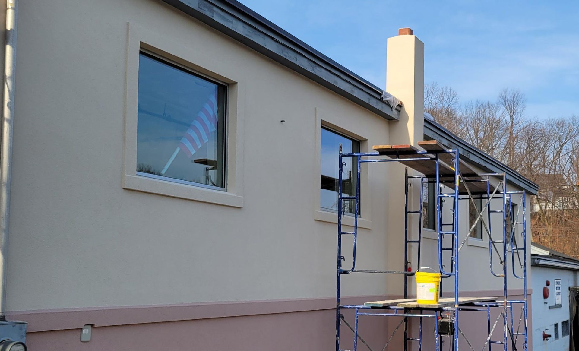 A house is being painted with scaffolding in front of it