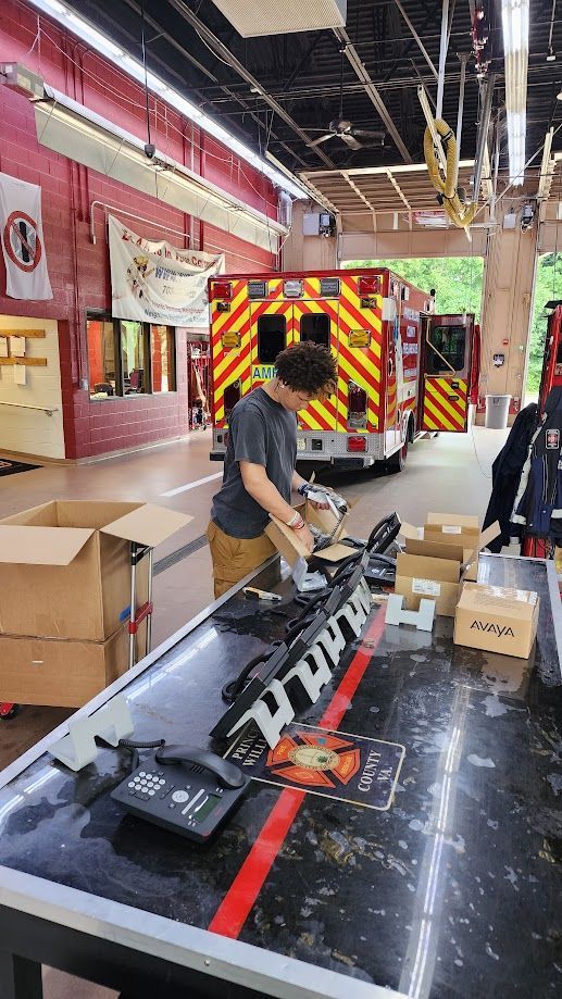 A man is working on a fire truck in a fire station.