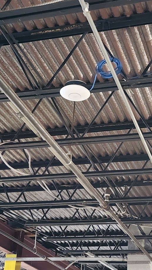 The ceiling of a building with a light hanging from it.