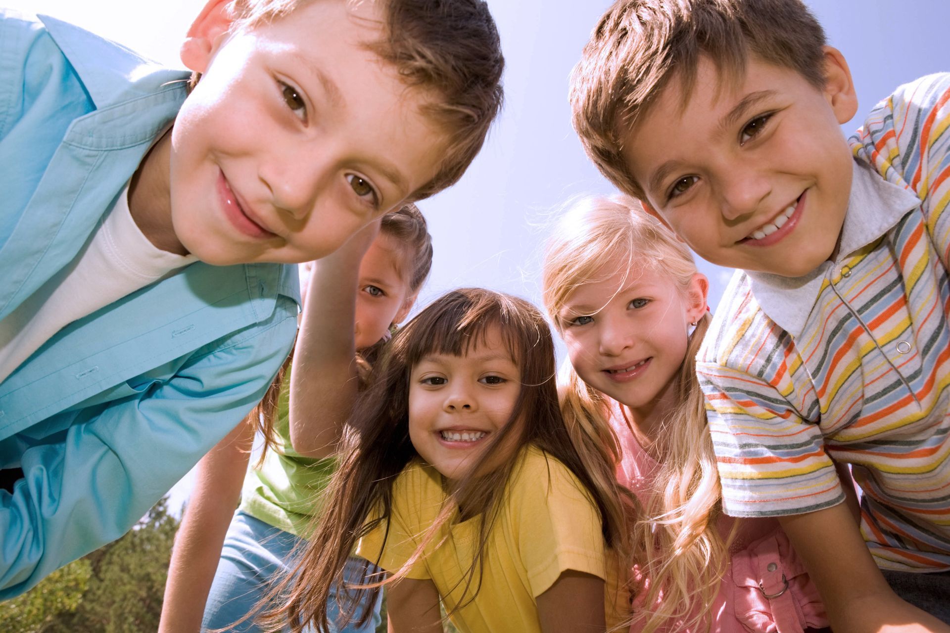 A group of children are posing for a picture and smiling for the camera