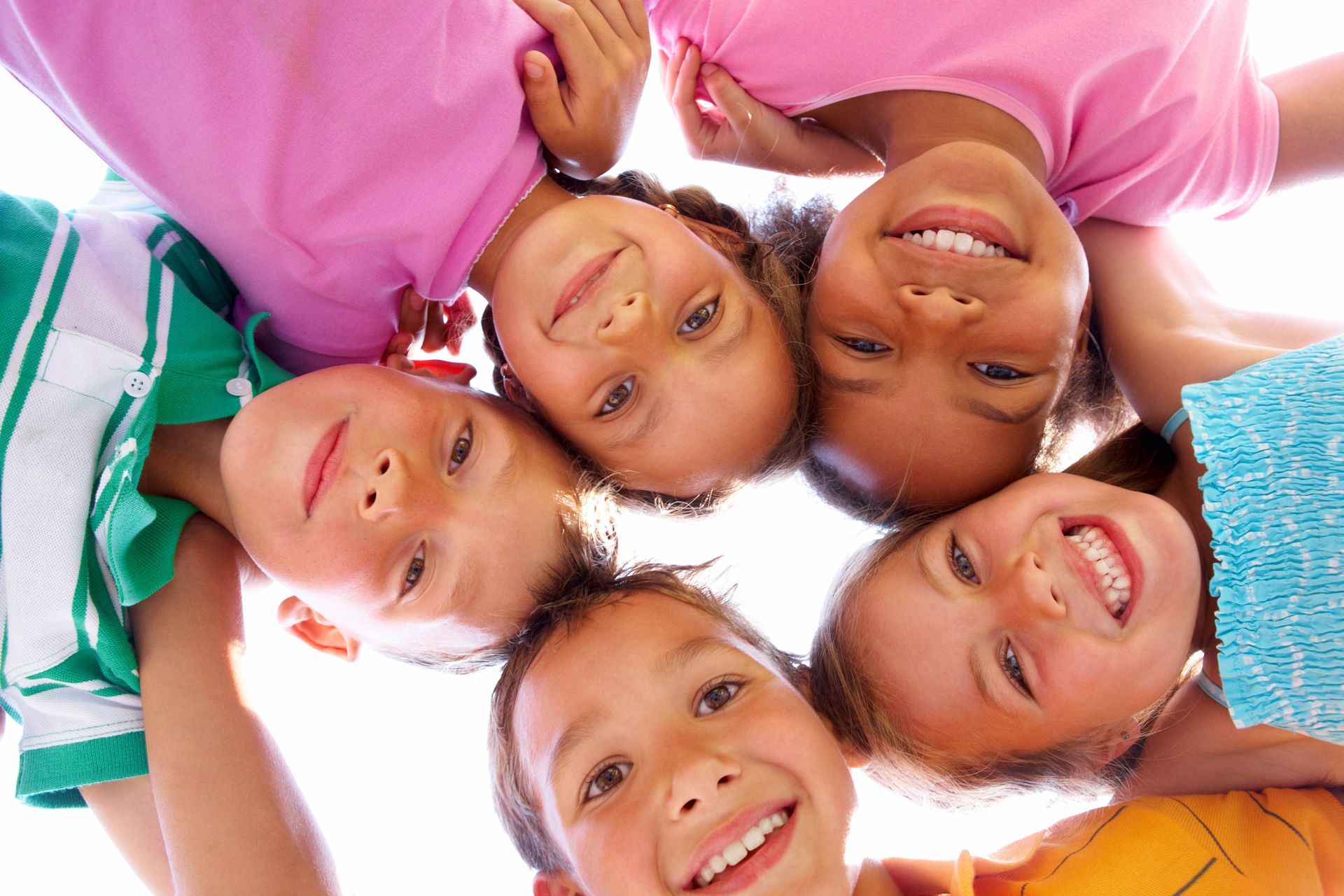 A woman is playing with two little girls at a table
