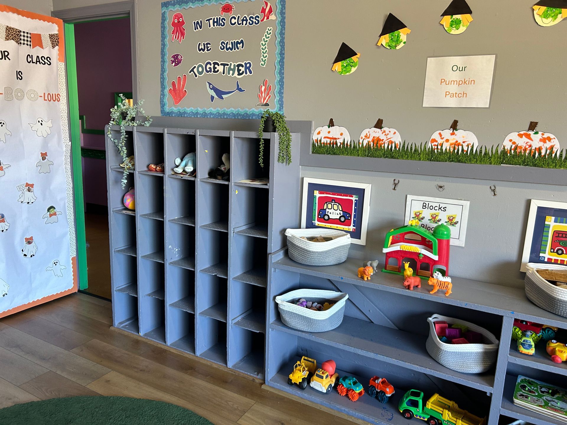 Childcare room with gray cubby shelves, toys, and pumpkin decorations.