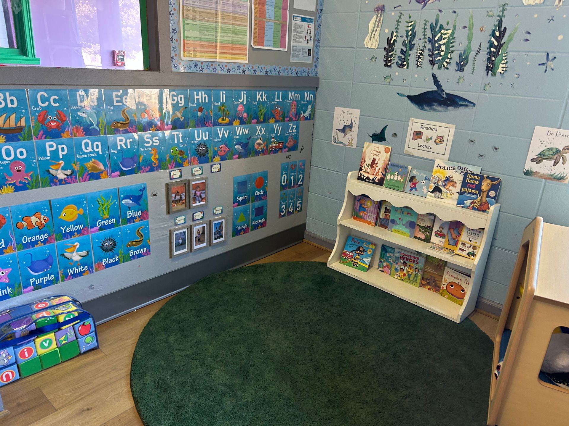 Ocean-themed classroom corner with alphabet, books, and green rug.