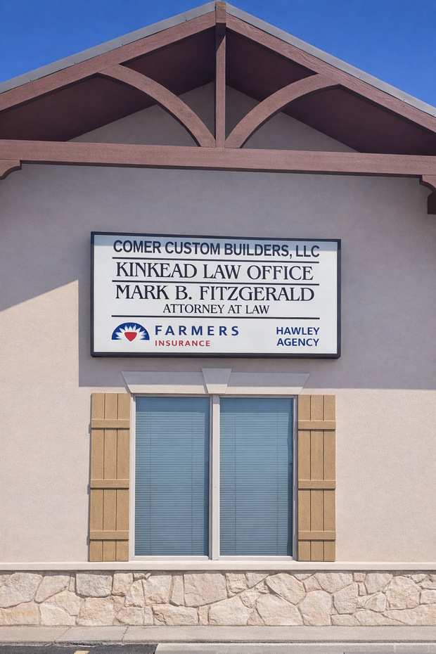 A tan building exterior with a multi-tenant business sign above a window with wooden shutters and a stone base.