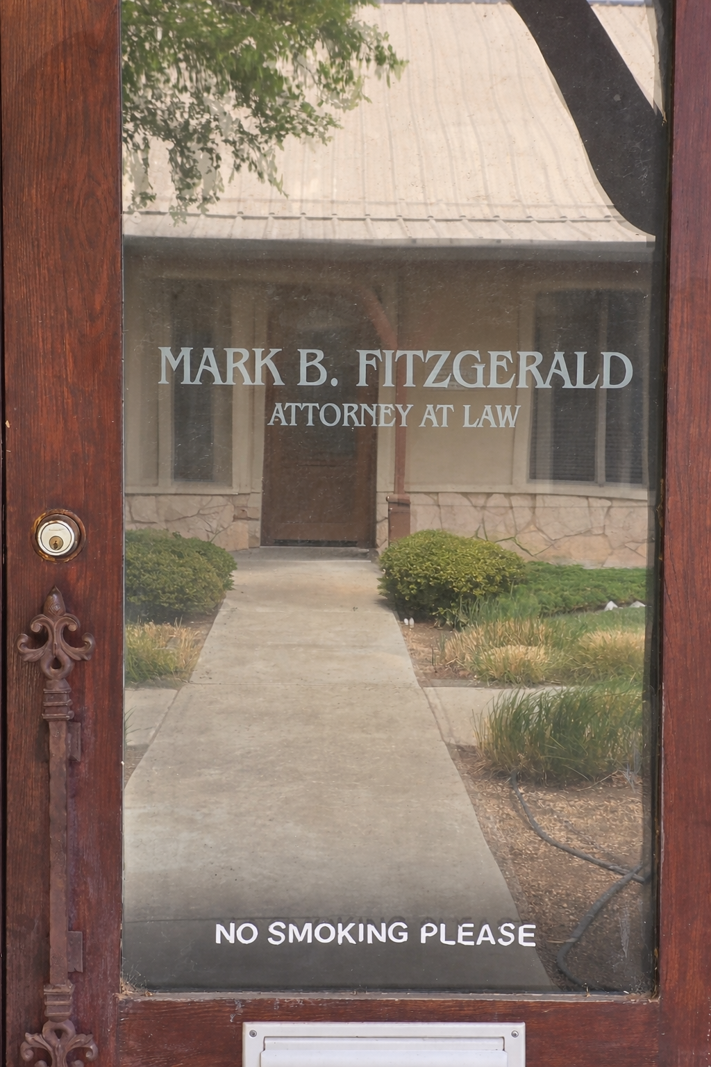 A glass door with white lettering reading Mark B. Fitzgerald, Attorney at Law and No smoking please.