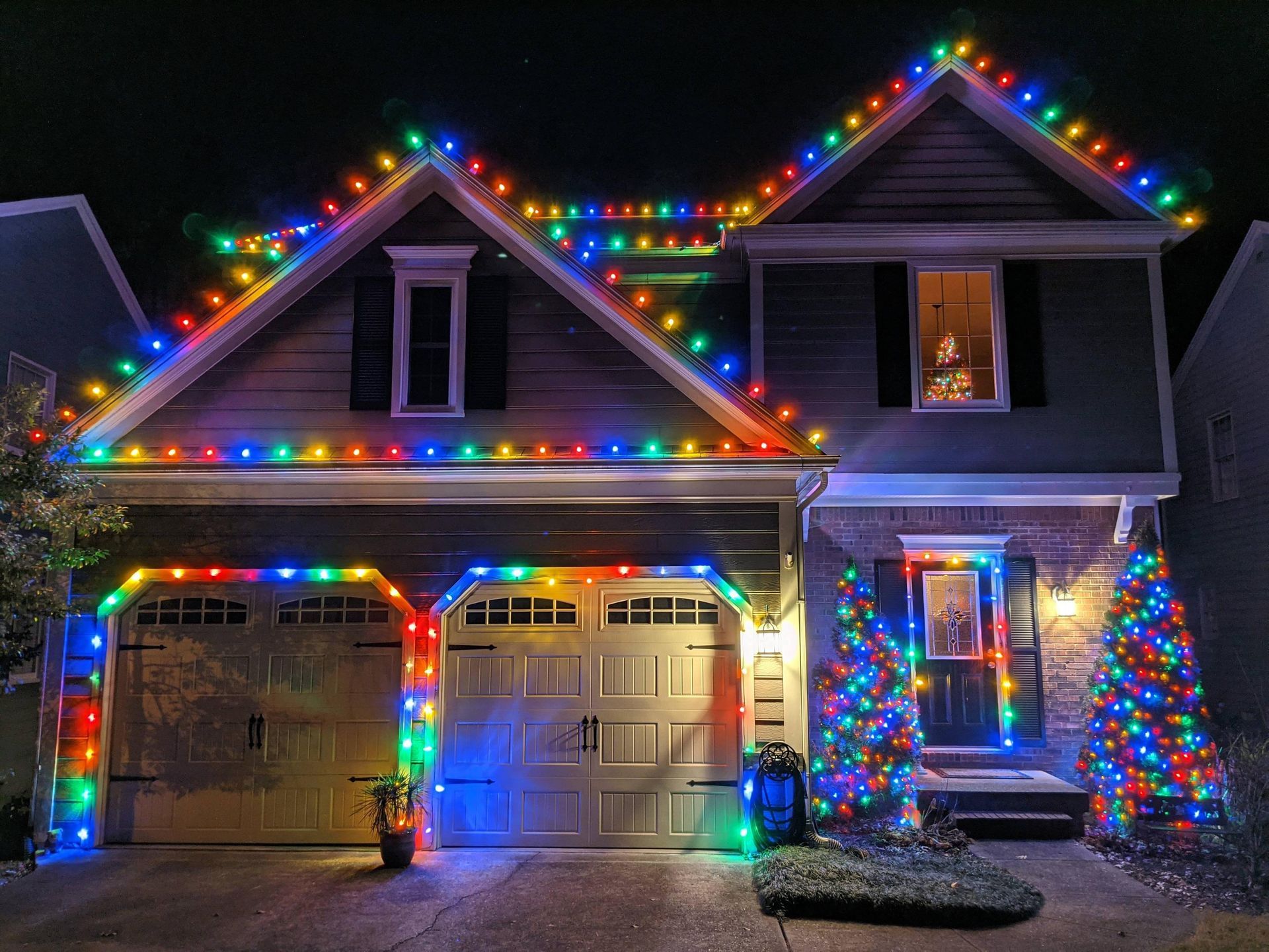 House decorated with colorful Christmas lights at night.