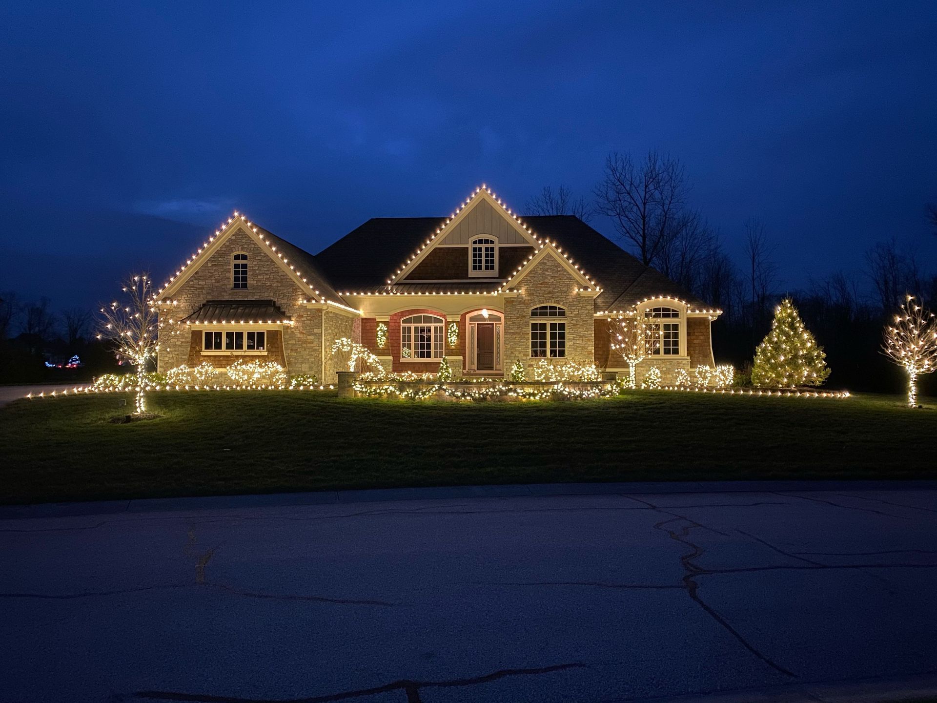 House decorated with white Christmas lights at dusk.